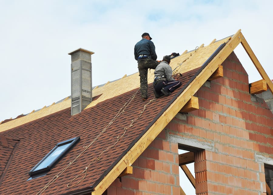 Roofing crew working near a ridge